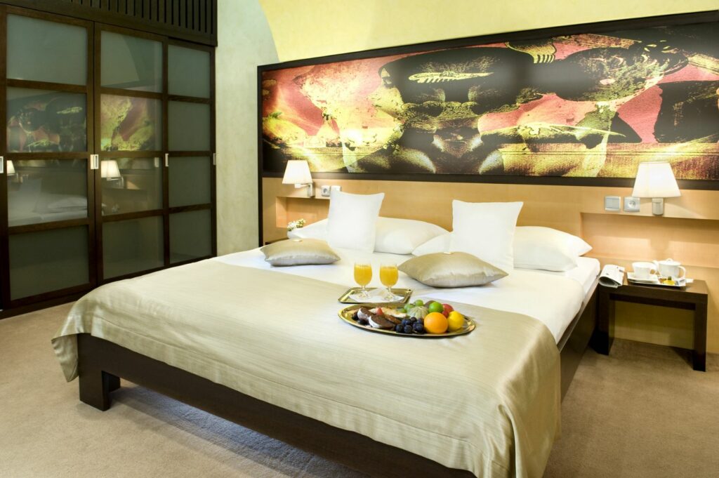 hotelová izba s maželskou posteľou a ovocím na tanieri