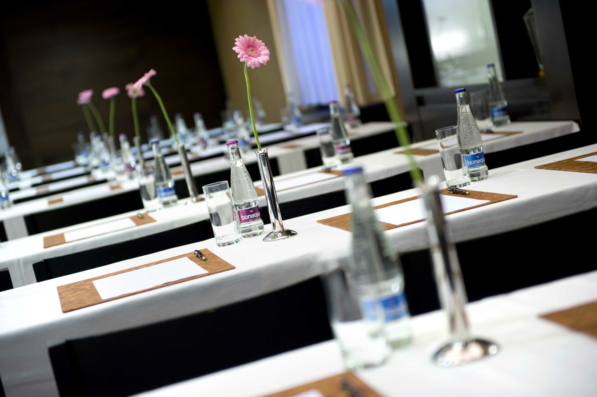 konferenčné priestory - stoly s kvetami a minerálkou